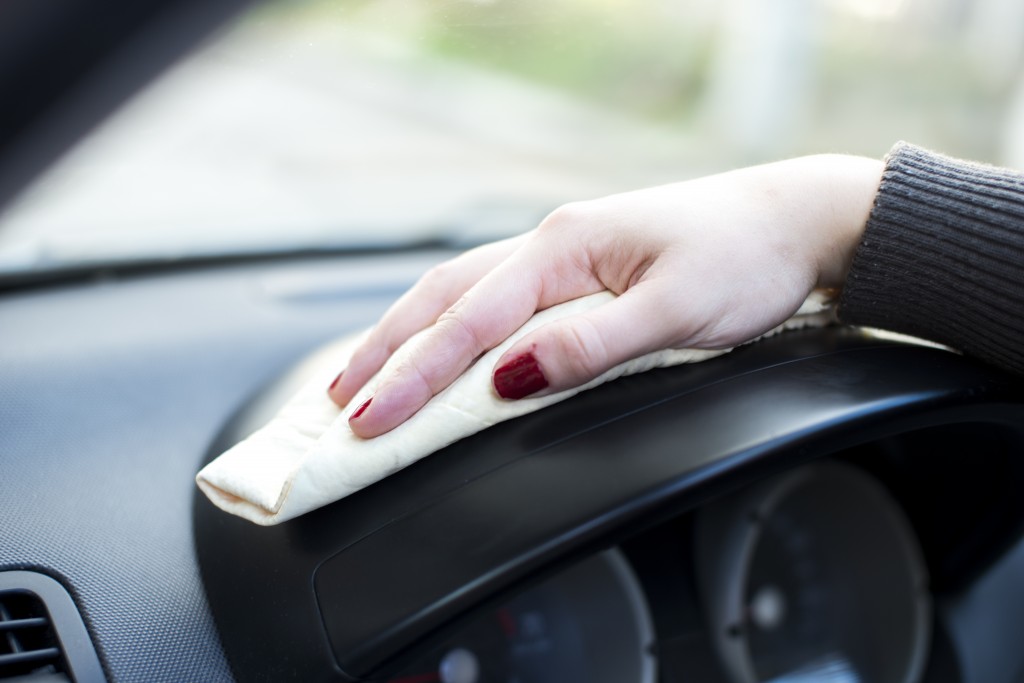 women hand polishing car bonnet with wiper at automobile repair