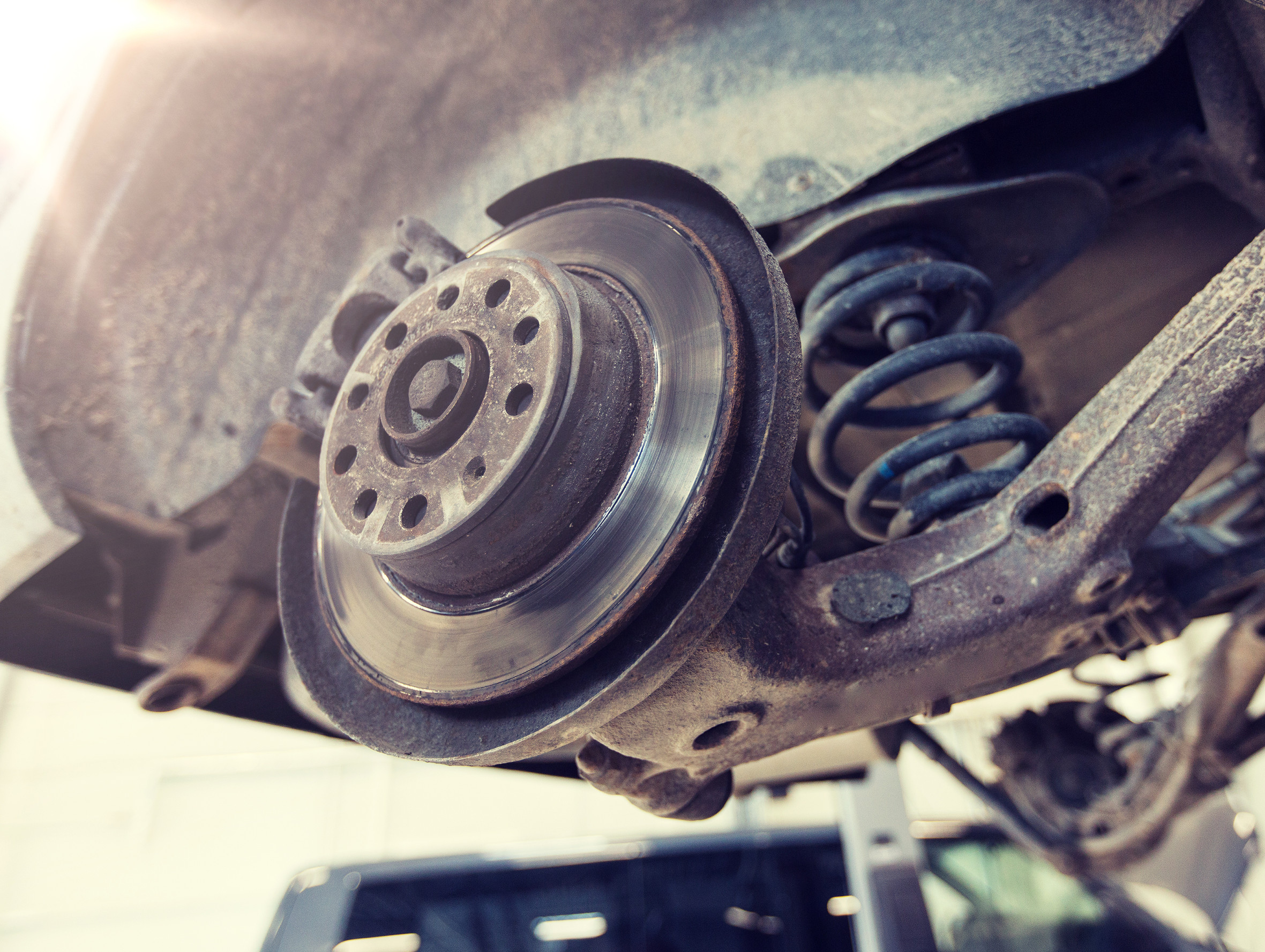 Mechanik kontroluje stav tlmičov na osobnom aute.