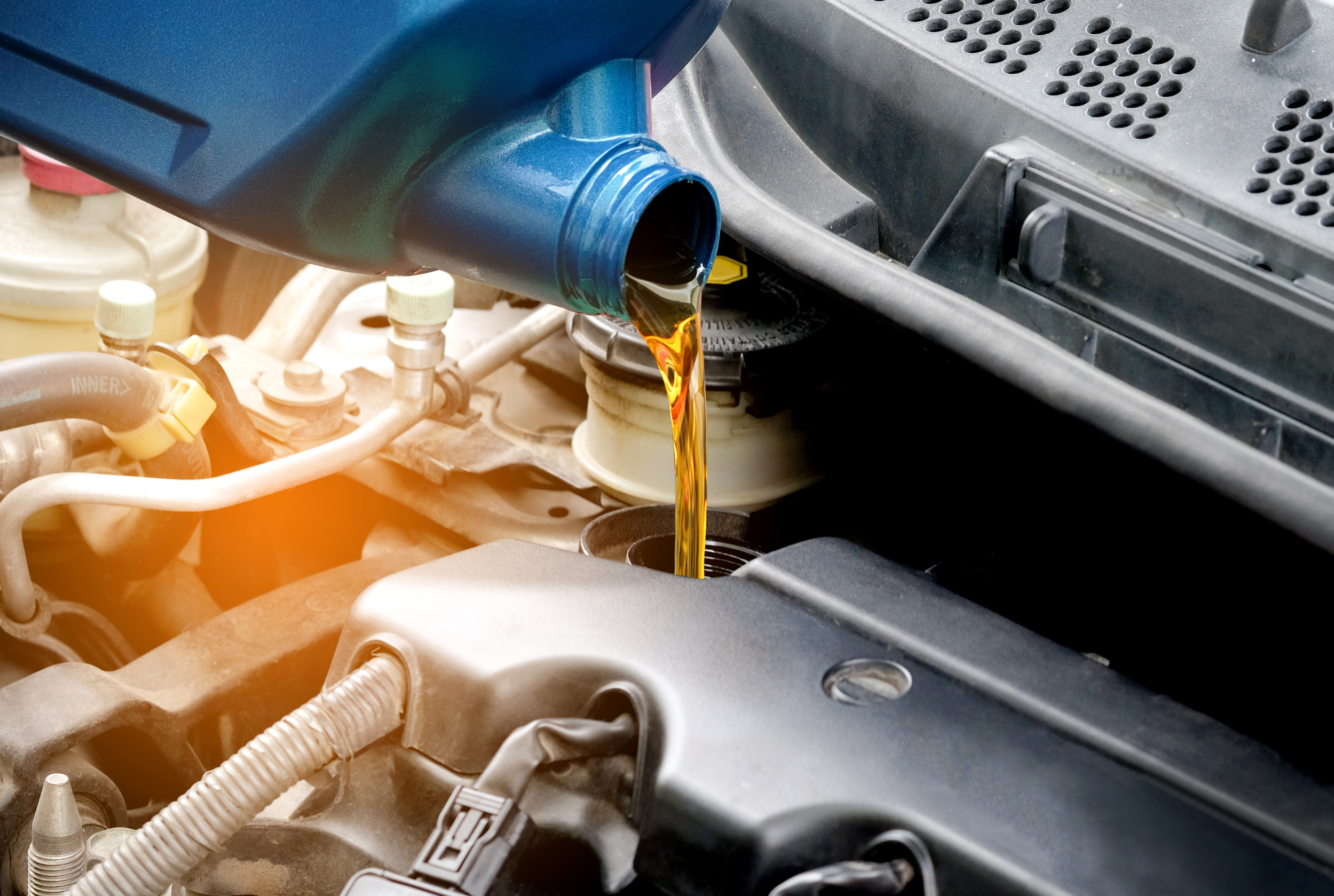 Kontrola hladiny motorového oleja pomocou mierky pri otvorenej kapote auta.